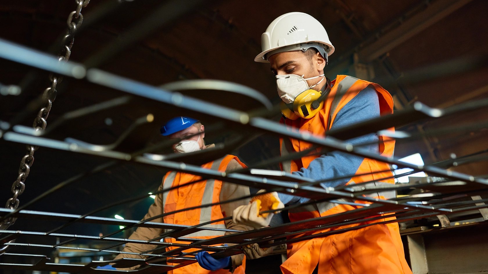 Arbeiter mit Schutzmaske in einem Metallbetrieb