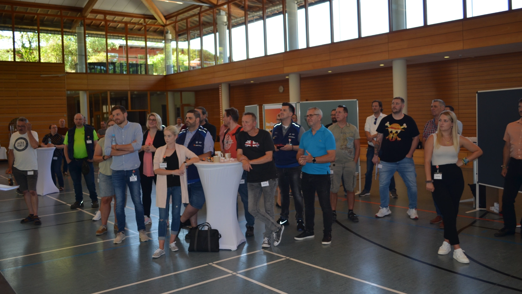 Teilnehmer schauen auf die in der Mitte liegende Bühne