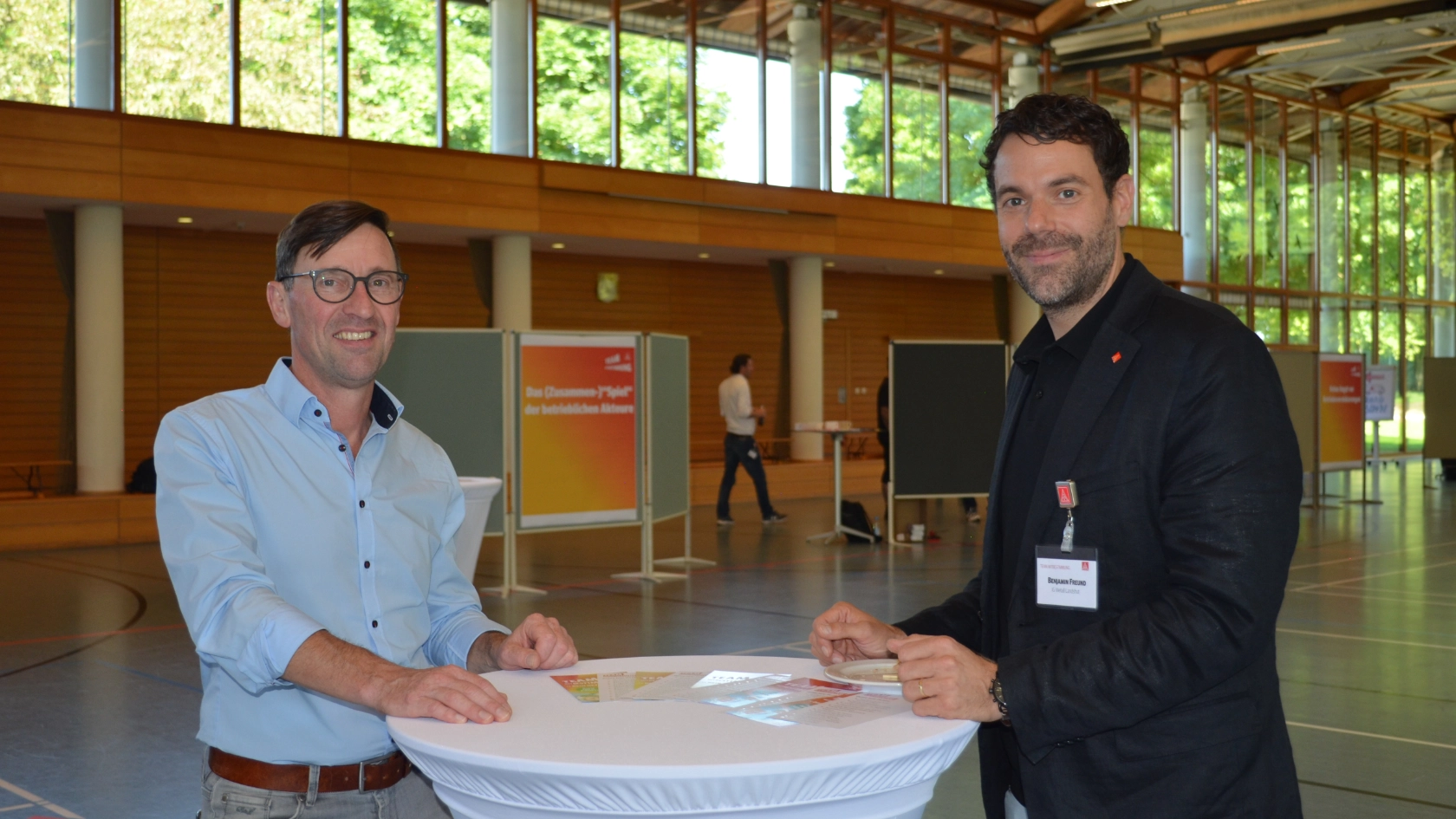 Kollege Rudi Lang und Benjamin Freund stehen zusammen am Stehtisch